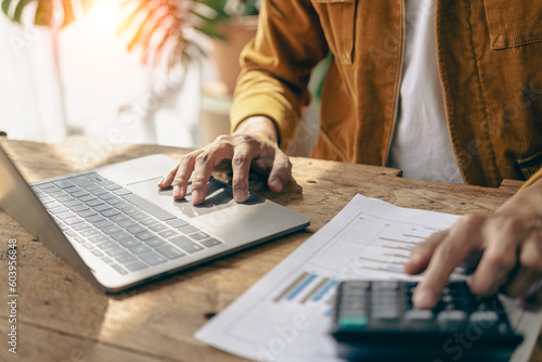 Businessmen hold graph documents to calculate financial analysis. Close-up of a businessman holding a pen while reviewing financial statements for business performance or return on investment.