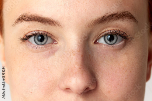 Cropped portrait with eyes of young girl, woman, girl with blue eyes over white background. Close up image. Plastic surgery. Vision correction