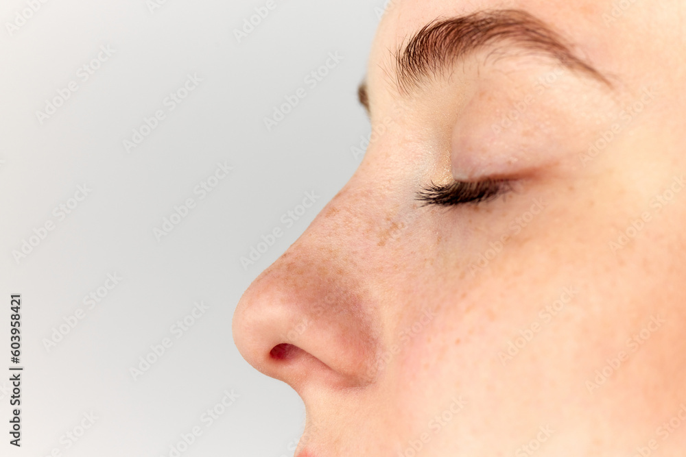 Young woman, girl demonstrating nose after, before surgery over white studio background. Side view. Rhinoplasty - obrazy, fototapety, plakaty 