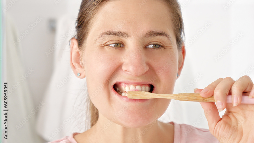 Slow motion shot of young woman brushing her teeth and looking in mirror. Concept of teeth health, self checking mouth and oral hygiene. Slow motion shot of young woman brushing her teeth and looking in mirror. Concept of teeth health, self checking mouth and oral hygiene.