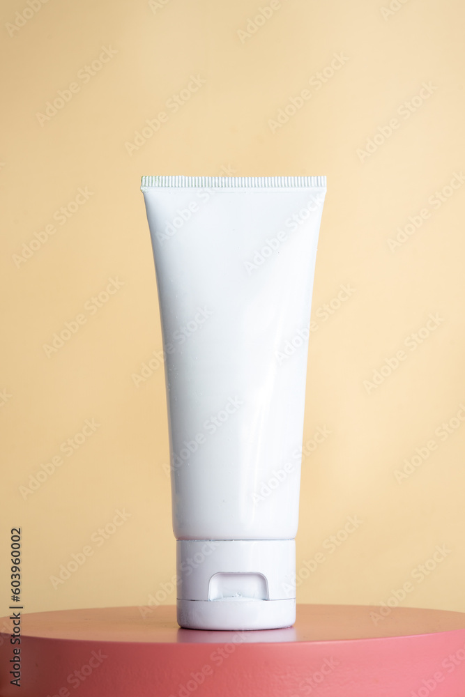 Blank tube cream mockups. White cosmetic packaging on pink podium Blank tube cream mockups. White cosmetic packaging on pink podium