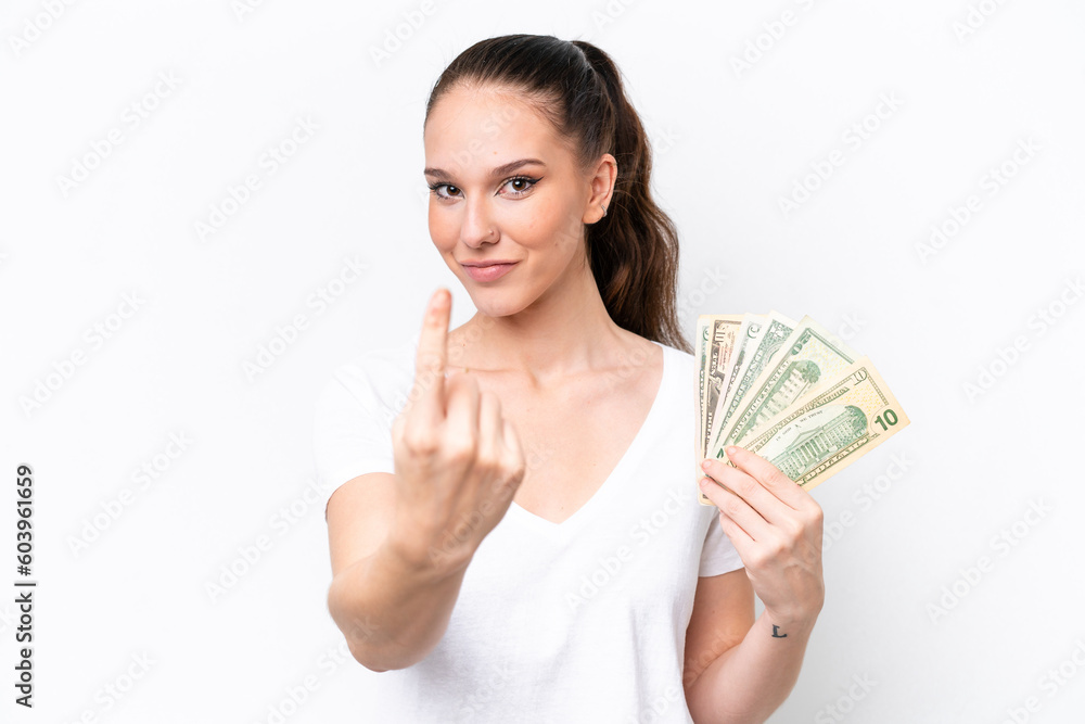 Young caucasian woman taking a lot of money isolated on white background doing coming gesture Young caucasian woman taking a lot of money isolated on white background doing coming gesture