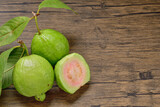 Top view, flat lay Pink Guava Slice fruit with fresh green leaves on wooden background. for copy space.copy text.for advertising design.Fruits and drinks.Foods and Drinks concept.