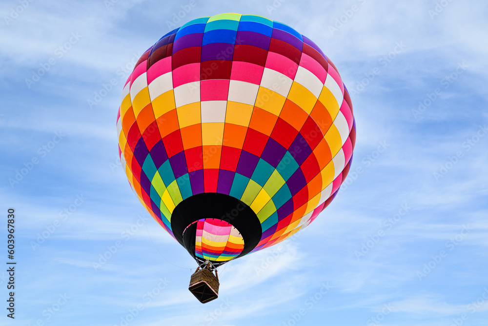 Naklejka premium Colorful hot air balloon flying over blue sky with white clouds 