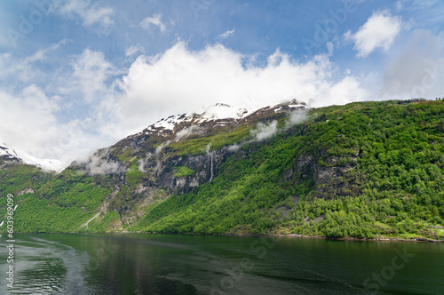 Beautiful landscape with snowy mountain peaks and waterfalls in Geiranger fjord, Norway