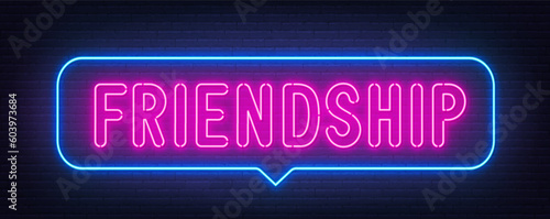 Friendship neon sign in the speech bubble on brick wall background.