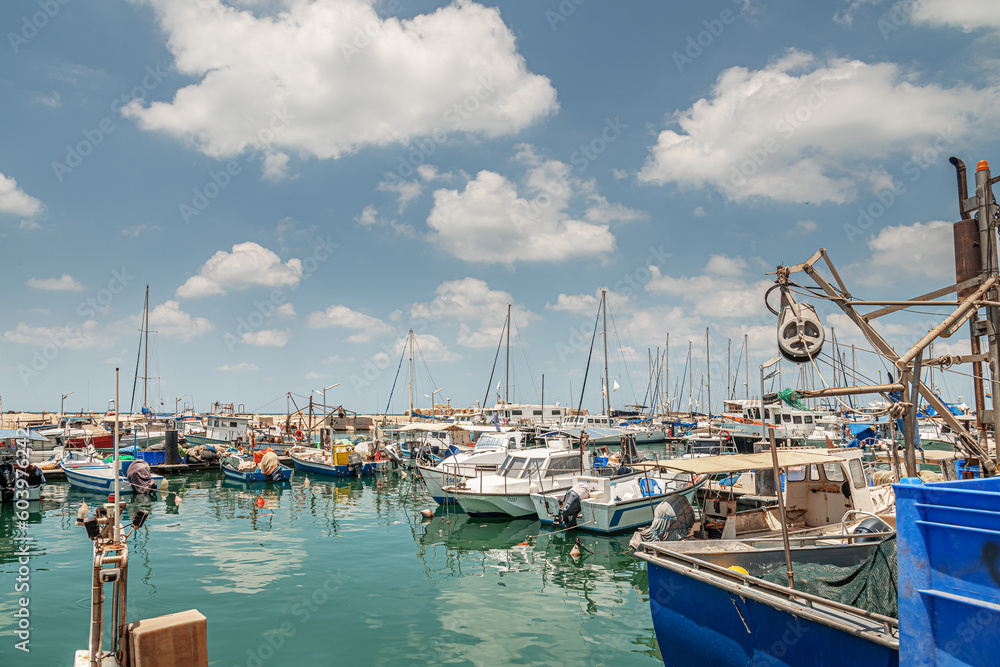 yachts and fishing boats on the pier at the marina  on a bright sunny day