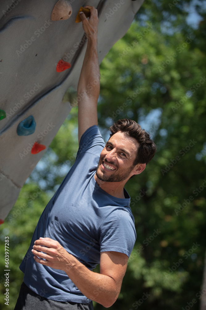 happy sports guy climbing a wall happy sports guy climbing a wall