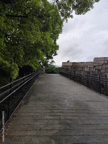 Espace en pierre et de verdure dans un grand jardin asiatique et japonais, avec ciel gris, nuageux et pluvieux, une jungle mélangeant avec l'architecture d'une ancienne civilisation photo