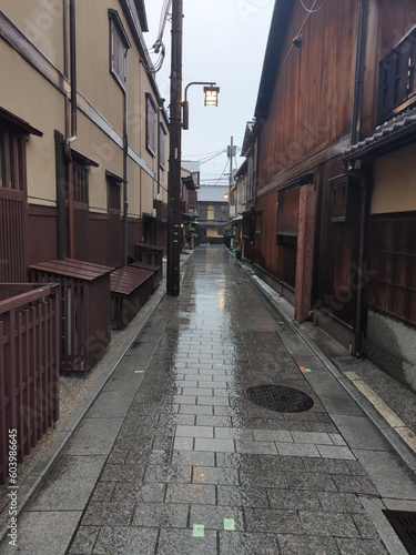 L'insolite et touristique quartier de Gion, avec des petites ruelles à l'asiatique, de l'ancien Japon, sous un temps de pluie, avec ciel nuageux, des gens se promenant avec des parapluies