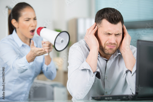 domineering female boss shouting at male office worker photo