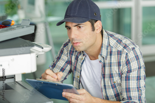 man technician repairing a printer at work