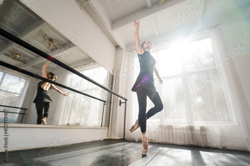 A beautiful Asian woman is dancing at the barre. Ballet dancer.