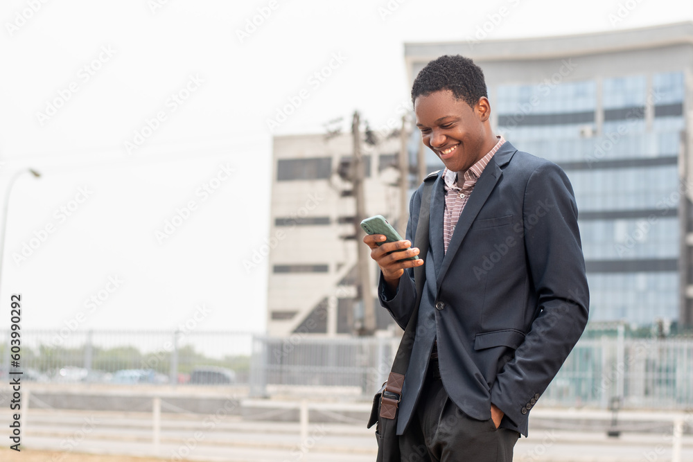 young african businessman smiling while using phone young african businessman smiling while using phone