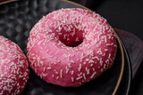 Delicious fresh sweet donuts in pink glaze with strawberry filling