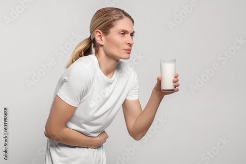 Obraz na płótnie Woman with glass of milk suffering from lactose intolerance on white background