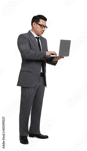 Businessman in suit working on laptop against white background