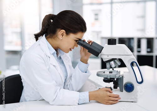 Scientist, research and woman with microscope in laboratory for medical study. Professional, science and female doctor with scope equipment for sample analysis, particle test and lab experiment.