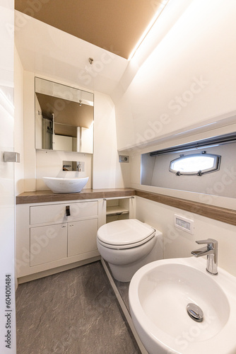 yacht Interior of a modern bathroom with white bathtub and toilet. Nobody inside