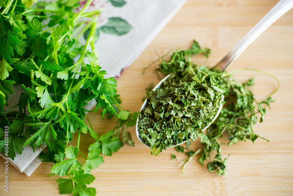 dried parsley in a spoon next to fresh herbs. dried parsley in a spoon next to fresh herbs.