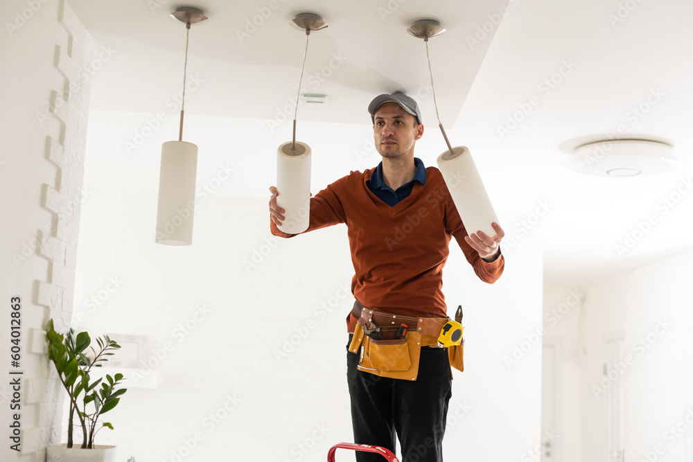 Electrician man working on exterior light, install LED replacement lamp at home. Maintenance concept. Electrician man working on exterior light, install LED replacement lamp at home. Maintenance concept.