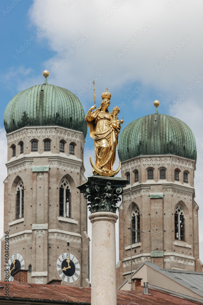 Marian column, Mariensäule, in front of the two towers of the  famous Cathedral Frauenkirche  at the Marienplatz in Munich, Germany