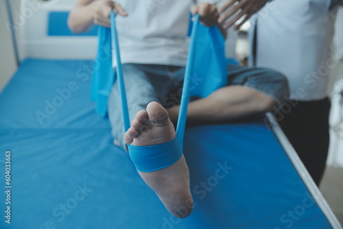 Doctor or physical therapist examines back pain and spinal area to give advice within the rehabilitation center.