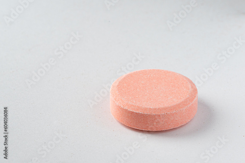 Close up of of chewable antacid acid reducer tablets with fruit flavor on white paper background