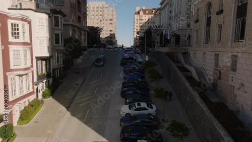 Forwards fly above steep rising street in city. Revealing luxurious hotel building in Nob Hill district. San Francisco, California, USA