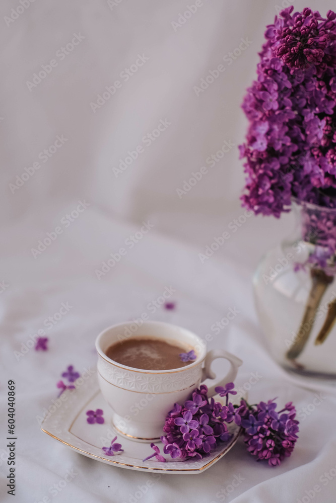 Cup of coffee with lilac flowers on a white background. Cup of coffee with lilac flowers on a white background.