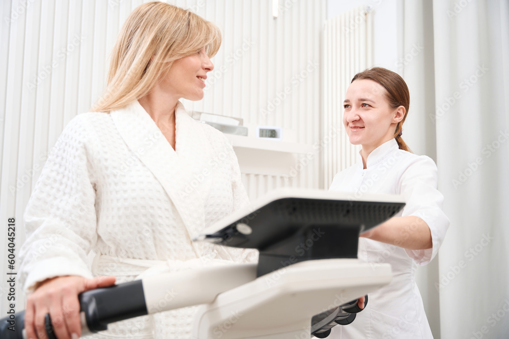 Lady in a medical center undergoes a bioimpedancemetry diagnostic procedure Lady in a medical center undergoes a bioimpedancemetry diagnostic procedure