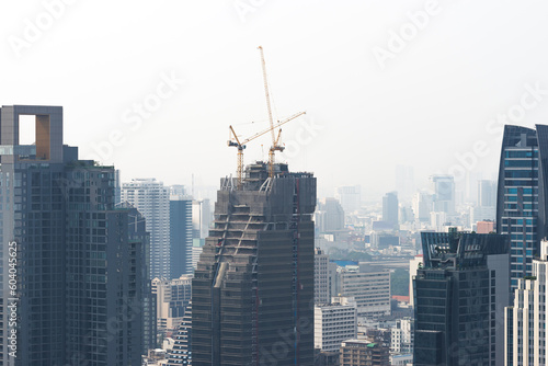 Construction of modern skyscrapers buildings in metropolis big city. Cranes on tower. Urban real estate