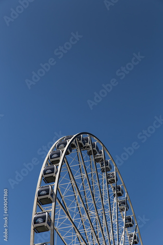 A Ferris wheel under the bright blue sky.