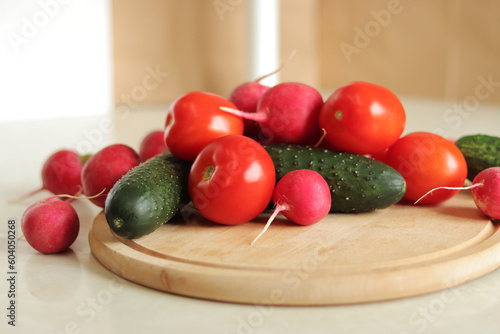 Fresh vegetables on the table, side view. Tomatoes, cucumbers and radishes. Vegetables for salad. Set of various fresh ingredients for making salad. Healthy food concept. Close-up