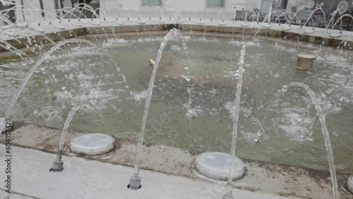 slow motion di getti d'acqua di una fontana in una piazza cittadina photo