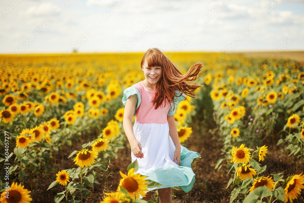 Happy little girl on the field of sunflowers in summer. beautiful little girl in sunflowers Happy little girl on the field of sunflowers in summer. beautiful little girl in sunflowers