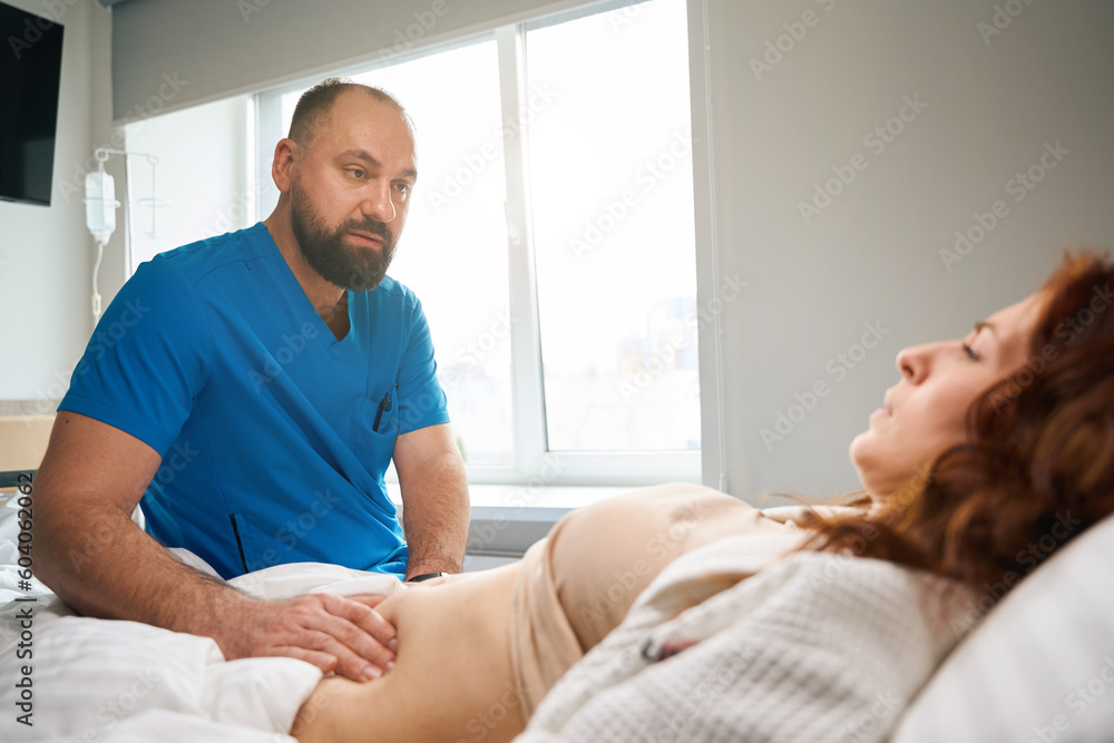 Fototapeta premium Sick woman being observed by doctor in health center
