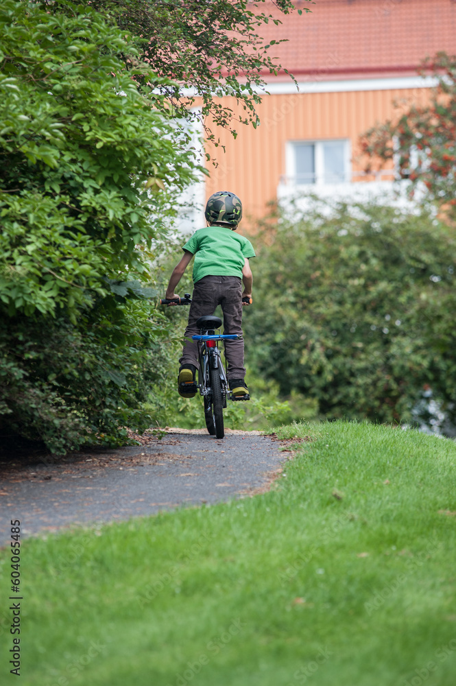Young kid cycling on a childs bike in a park. Young kid cycling on a childs bike in a park.