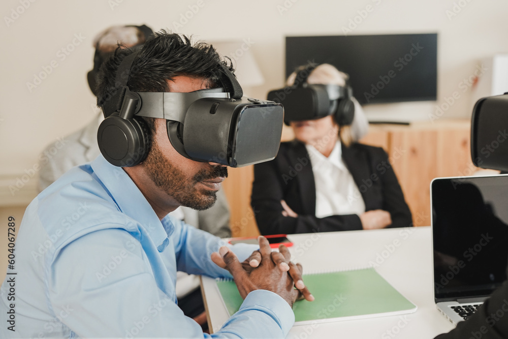 Multiracial business people using virtual reality technology inside modern office - Soft focus on young indian man face Multiracial business people using virtual reality technology inside modern office - Soft focus on young indian man face