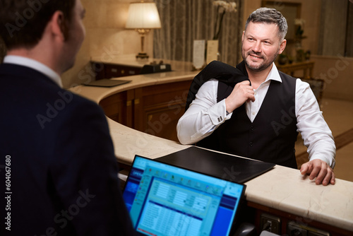 Konstfotografi Handsome businessman talking with male receptionist in the hotel