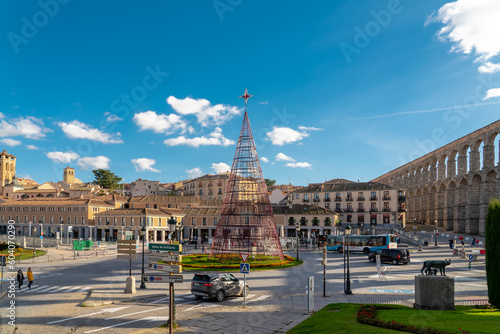 SEGOVIA, Spain - November 13 2022: City center of Segovia prepared for Christmas Celebration. Christmas tree in the middle of the plaza. At right is the famous aqueduct. Travel destination in Spain  photo