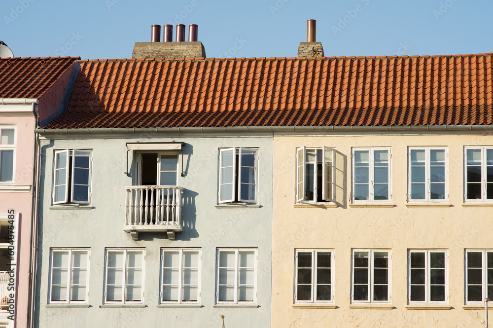 Green and yellow historic terraced houses in Nyhavn in the center of Copenhagen in Denmark