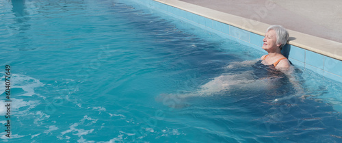Картината върху платно Senior woman sitting with closed eyes in outdoor swimming thermal pool with warm water
