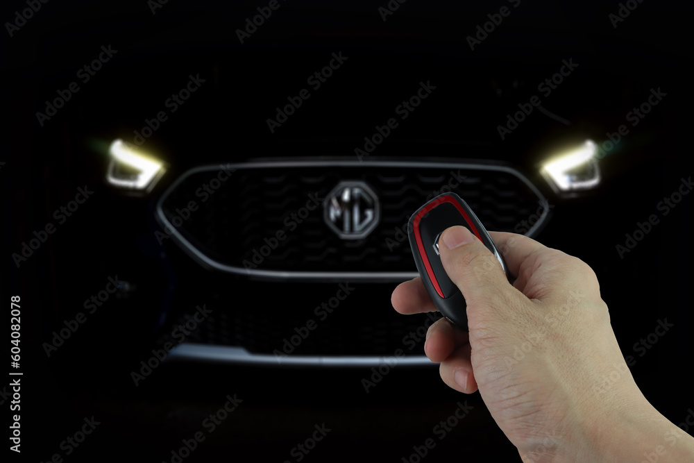 right hand holding car remote key to unlock suv car MG ZS model with
