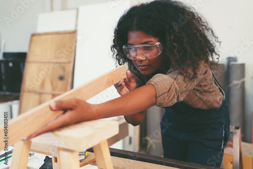 Fotografi Female carpenter working in wood workshop