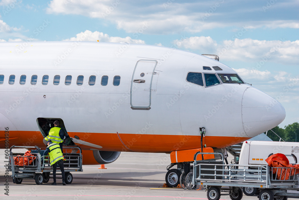 Airplane luggage loading at airfield Airplane luggage loading at airfield