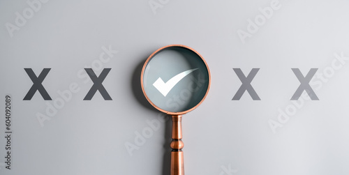 Magnifier enlarging the correct or check mark on gray background. Business industrial quality control and voting concept. Approval and Contract assignment theme.