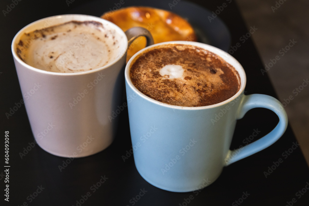 Two Cappuccino. Mugs full of coffee with milk foam and cinnamon Two Cappuccino. Mugs full of coffee with milk foam and cinnamon
