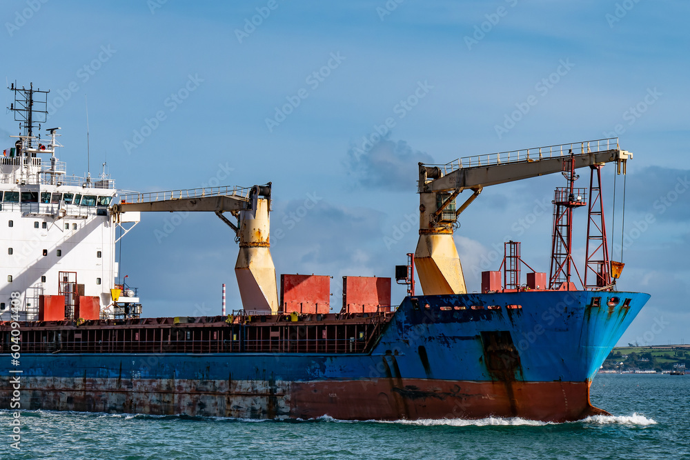 An old rusty big ship is sailing on the sea under a blue sky.The bow of the ship. An old rusty big ship is sailing on the sea under a blue sky.The bow of the ship.