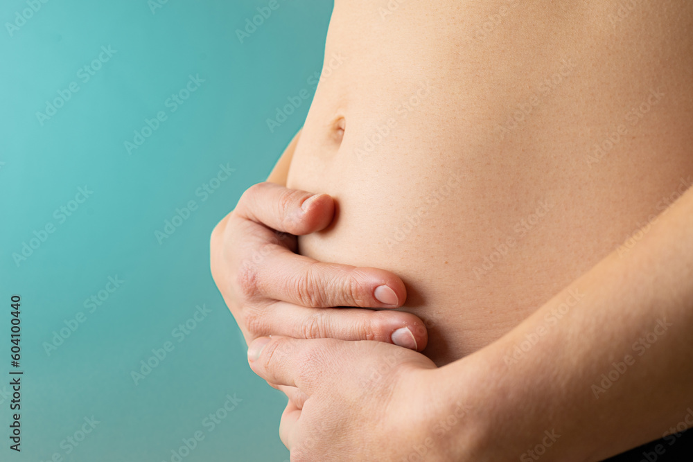 Φωτογραφία Very close up view of woman in first months of pregnancy gently holding her belly